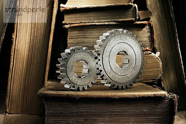 Stillleben mit alten Metallzahnrädern und antiken Büchern. Kurze Tiefenschärfe