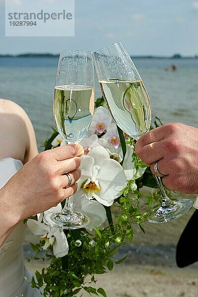 Anstoßen mit den Gläsern von Braut und Bräutigam