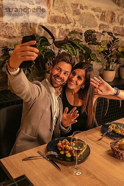 Lifestyle  ein junges  verliebtes Paar in einem Restaurant  das Spaß am gemeinsamen Essen hat  den Valentinstag feiert und ein Selfie als Andenken macht. Vertikales Foto