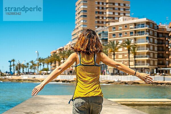 Eine junge Frau genießt den Urlaub in der Küstenstadt Torrevieja  Alicante  Valencianische Gemeinschaft. Spanien  Mittelmeer