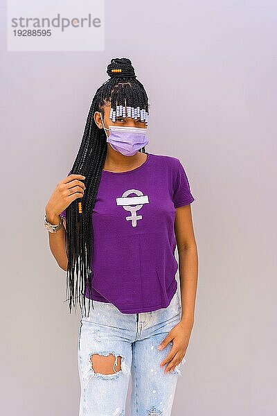 Internationaler Frauentag im Jahr der Coronaviruspandemie Covid 19. Dominikanische Frau mit feministischem lila Hemd