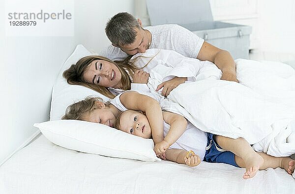 Seitenansicht glückliche Familie im Bett