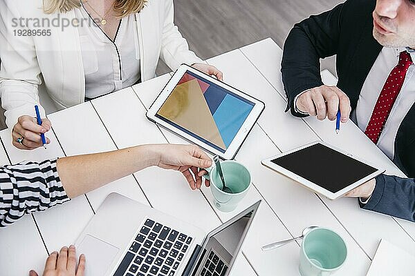 Crop Geschäftsleute mit Gadgets Schreibtisch