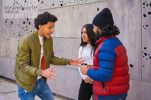 Urbaner Stil  drei schwarze Latino Freunde  die Spaß auf der Straße haben und miteinander reden. Afro Haar Junge  Brünette Junge mit langen Haaren mit Hut
