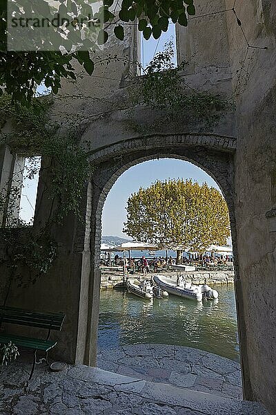 Tordurchgang mit Blick auf idyllischen Hafen und Mole  Herbst  Taverne Hotel Locanda San Vigilio  Punta San Vigilio  Gardasee Ostufer  Venetien  Provinz Verona  Italien  Europa