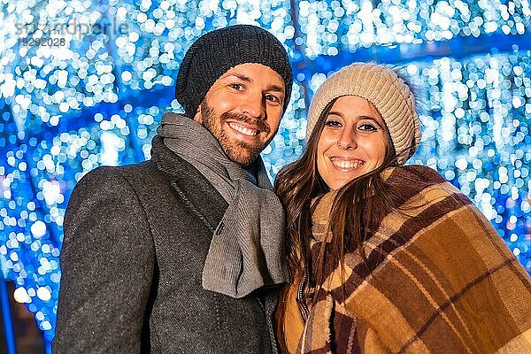 Ein junges europäisches Paar genießt die Weihnachtsbeleuchtung in der Stadt