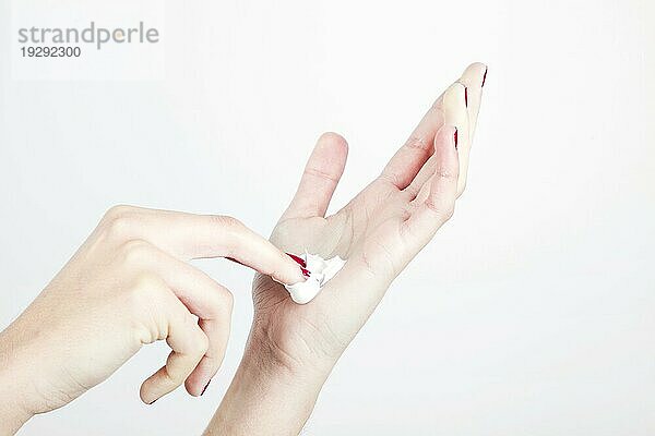 Close up Frau s Hand mit Feuchtigkeitscreme isoliert weißem Hintergrund