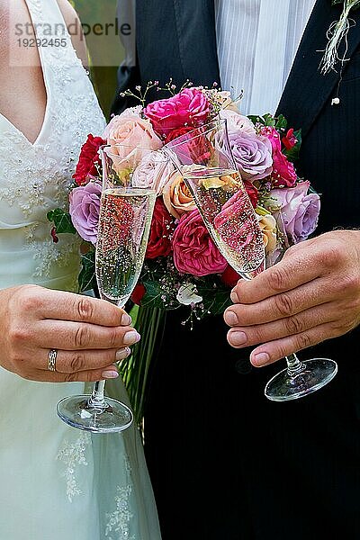 Anstoßen mit den Gläsern von Braut und Bräutigam