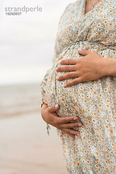 Silhouette einer schwangeren Frau in einem weißen Kleid am Strand  schwanger Sitzung einer neuen Schwangerschaft