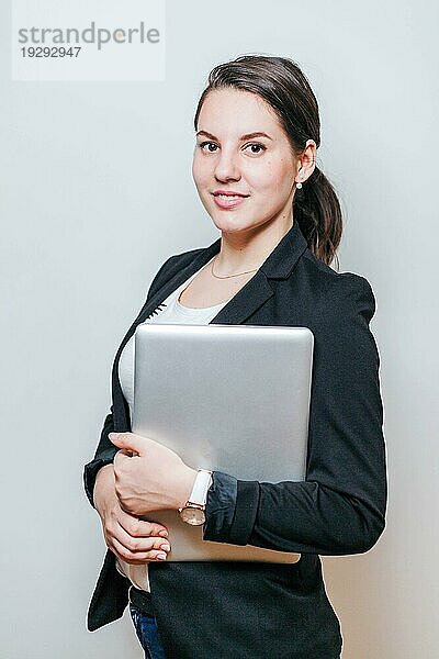 Büroangestellter stehend mit Laptop