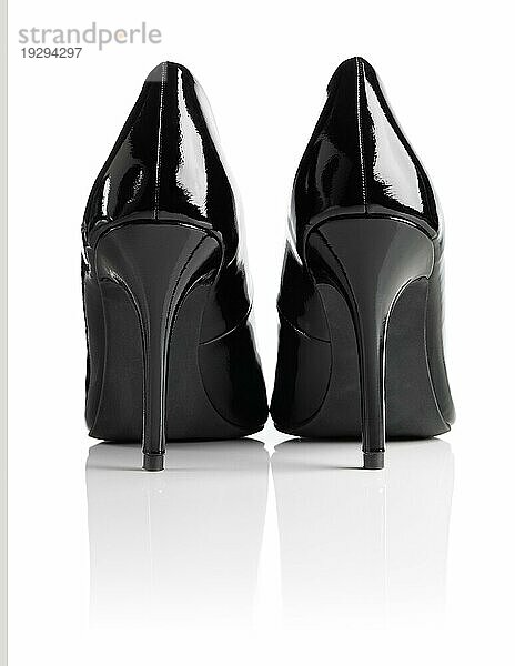 Schwarz glänzendes Lackleder Stiletto Heel Pumps vor weißem Hintergrund mit natürlichen Reflexion
