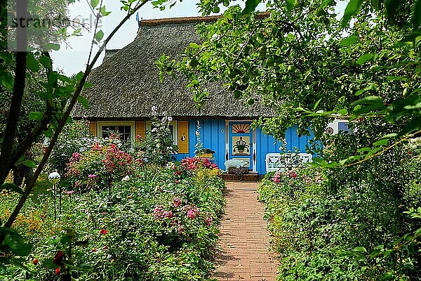 Idyllischer Garten mit blauem Fischerhaus
