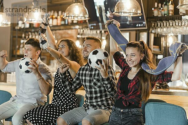Fußballfans sitzen an der Bar und feiern den Sieg