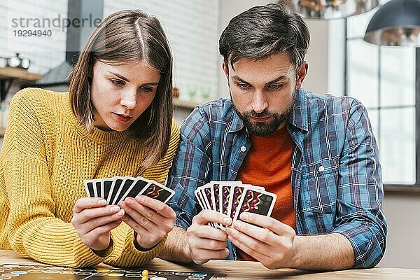Seriöses junges Paar  das seine Karten beim Brettspiel betrachtet