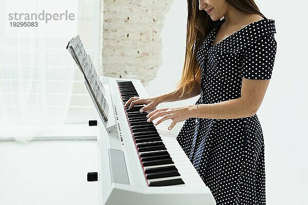 Close up lächelnde junge Frau spielt Klavier