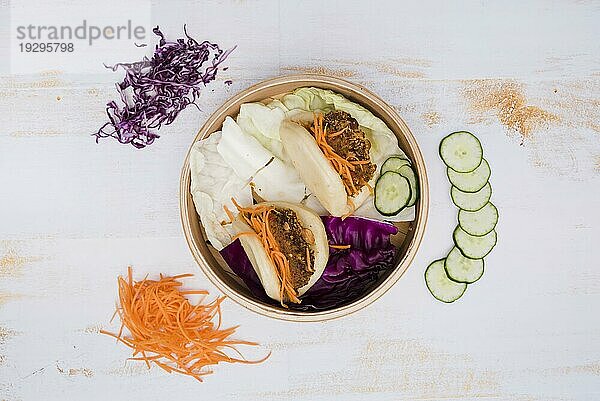 Erhöhte Ansicht taiwan s traditionelles Essen gua bao Dampfer mit Salat hölzerne Textur Kulisse