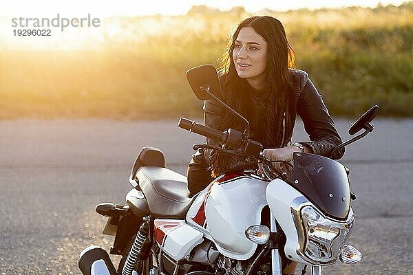 Smiley Frau ruht ihr Motorrad Sonnenuntergang