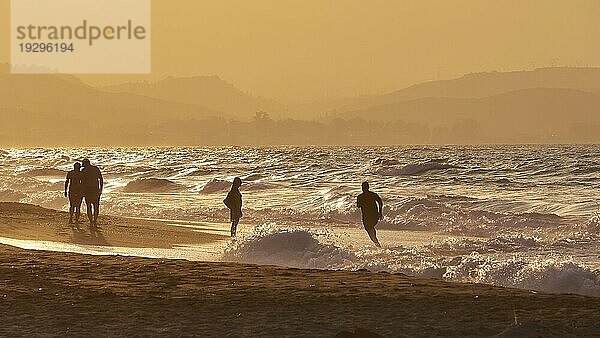 Abendlicht  Sonnenuntergang  kupferfarbenes Licht  Starke Brandung  Wellen  Menschen als Silhouletten  Strand  Nordküste  Kreta  Griechenland  Europa