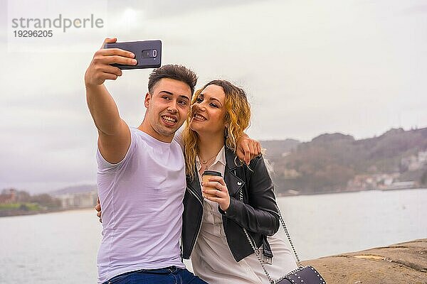 Lebensstil eines kaukasischen Paares  das Sehenswürdigkeiten besichtigt und den Urlaub genießt. Aufnahme eines Selfiefotos mit dem Mobiltelefon
