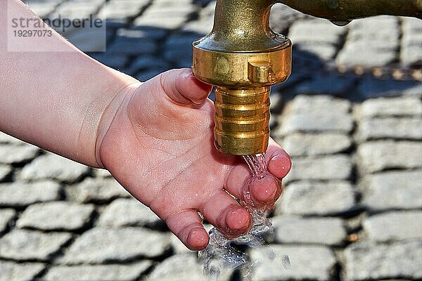 Durstige Kinder mit der Hand am Wasserhahn