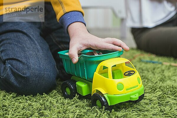Kind spielt Spielzeugauto Boden