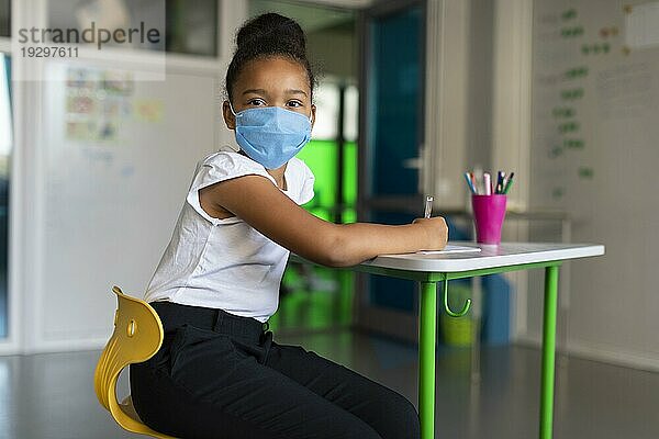 Kleines Mädchen mit medizinischer Maske Klasse