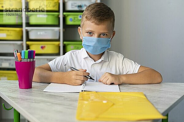 Kind trägt Gesichtsmaske Pandemiezeit
