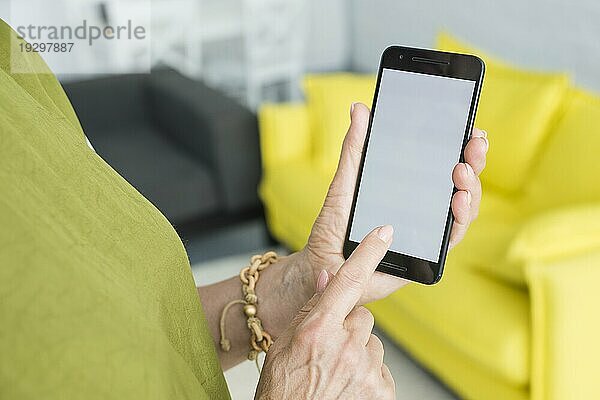 Ältere Frau berührt mit ihrer Hand den Handybildschirm