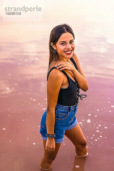 Lebensstil einer jungen brünetten Kaukasierin im Urlaub in der rosa Lagune von Torrevieja im Sommer  in Jeans und einem schwarzen TShirt Alicante. Spanien