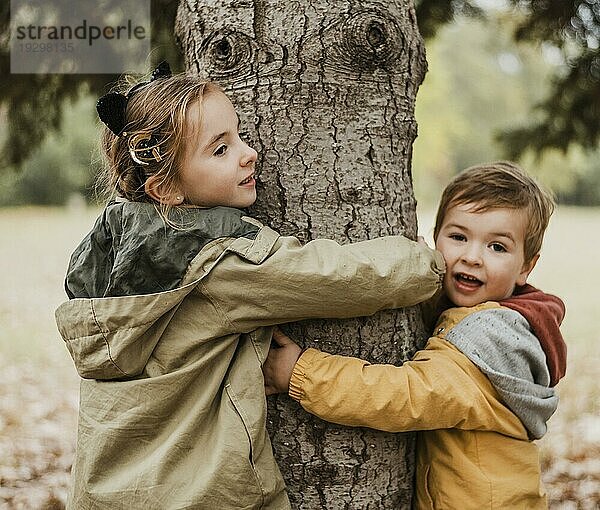 Medium shot Kinder umarmen Baum