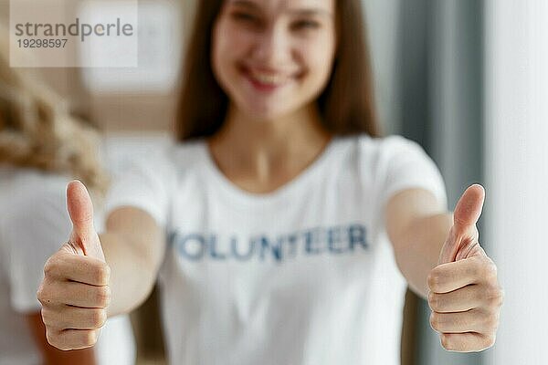 Vorderansicht unscharf  weibliche Freiwillige gibt Daumen hoch