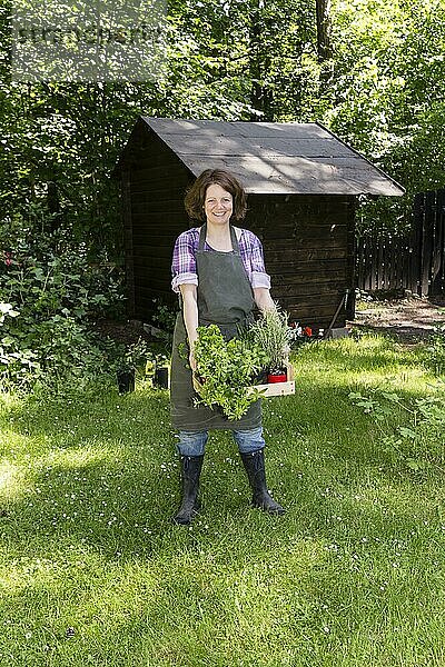 Frau mit Kräutern im Garten  woman with herbs in a garden