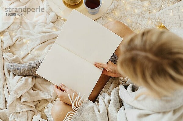 Frau liest ein Buch und genießt die Winterferien