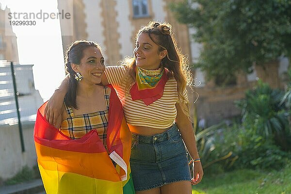 Eine Nahaufnahme von zwei jungen kaukasischen Frauen halten LGBT Stolz Flagge im Freien