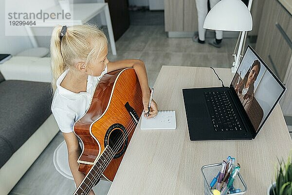 Junges Mädchen lernt Gitarre spielen