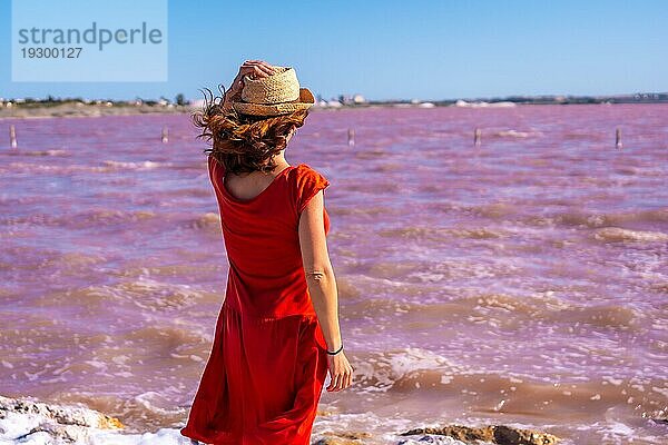 Mädchen mit rotem Kleid in der rosa Lagune von Torrevieja  Alicante. Gemeinschaft von Valencia. Spanien  Urlaub am Mittelmeer