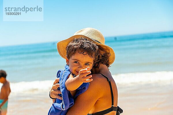 Mutter umarmt ihren Sohn und hat Spaß mit ihm am Meer  Algarve Strand  Albufeira. Portugal