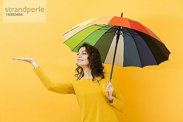 Vorderansicht Frau mit Regenbogenschirm