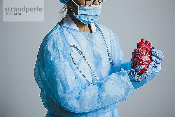Chirurg posiert mit Herz