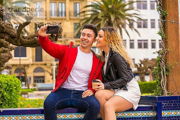 Lifestyle eines kaukasischen Paares beim Sightseeing im Urlaub  in einem Stadtpark  das ein Foto mit dem Handy macht