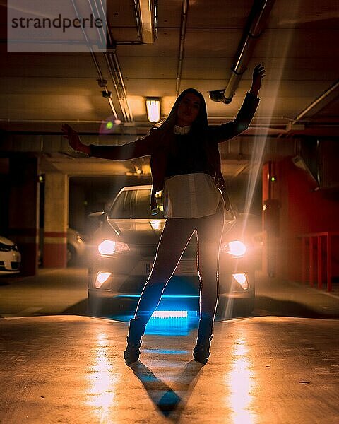 Fotografie mit blauen Leuchtreklamen vor einem Auto auf einem Parkplatz. Porträt einer jungen hübschen blonden kaukasischen Frau in Silhouette
