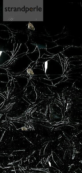 Steinbrechende Glasscheibe vor schwarzem Hintergrund