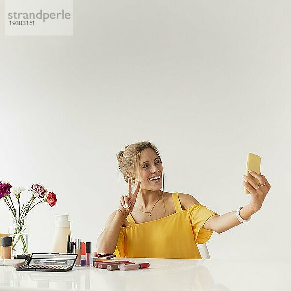 Frau macht Selfie und zeigt Zeichen des Friedens