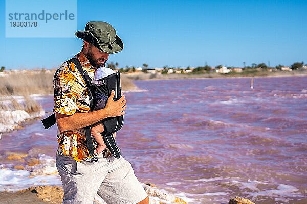 Junger Vater beim Besuch der rosa Lagune von Torrevieja  Alicante. Gemeinschaft von Valencia. Spanien  Urlaub am Mittelmeer