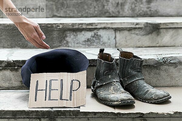 Obdachlose Person bettelt um Hilfe