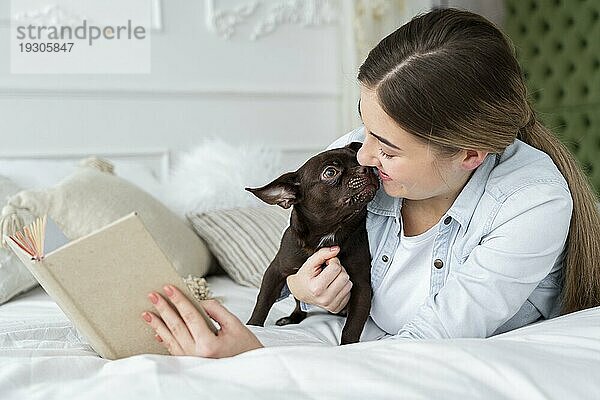 Close up Mädchen lesen Bett mit niedlichen Hund