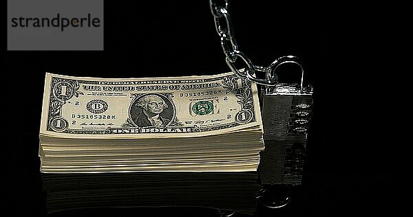 Vorhängeschloss und Dollar Banknoten gegen Blakc Hintergrund