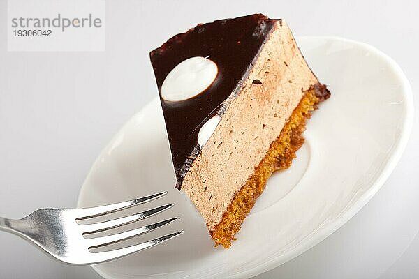 Leckerer Schokoladenkuchen auf weißem Teller mit Gabel. Unscharfer Fokus
