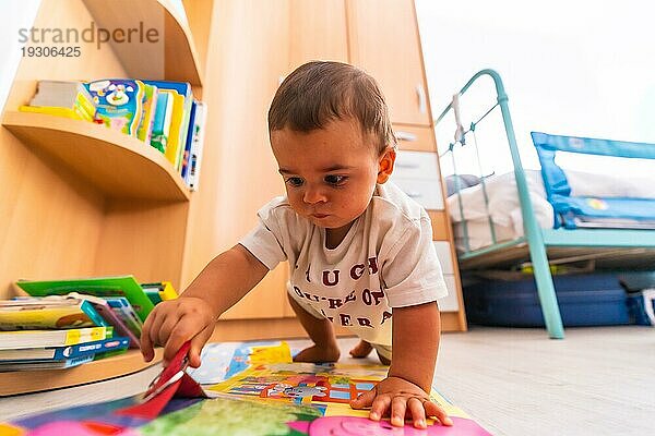 Junge kaukasische Mutter spielt mit ihr im Zimmer mit Spielzeug. Baby weniger als ein Jahr lernen die ersten Lektionen von ihrer Mutter. Junge spielt auf dem Boden mit Spielzeug