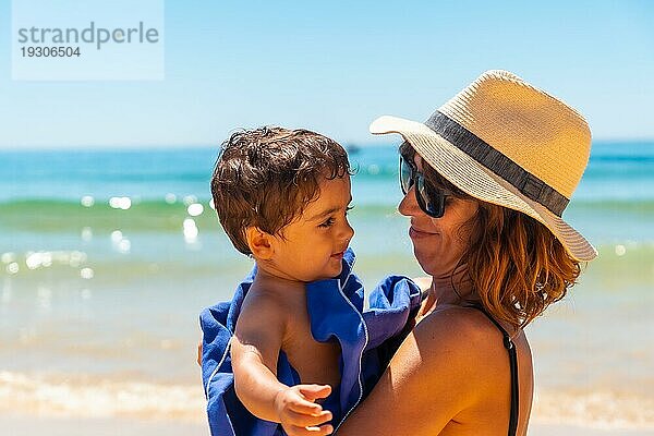 Mutter umarmt ihren Sohn und hat Spaß mit ihm am Meer  Algarve Strand  Albufeira. Portugal